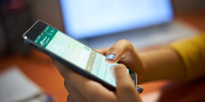 Woman holding phone and texting while at work