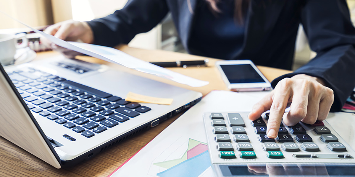 business woman look at paper and using a calculator on a desk