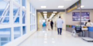 Blurred photo of a hospital hallway with doctors and nurses walking