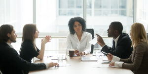 A group of disgruntled employees in a legal meeting talking across a table