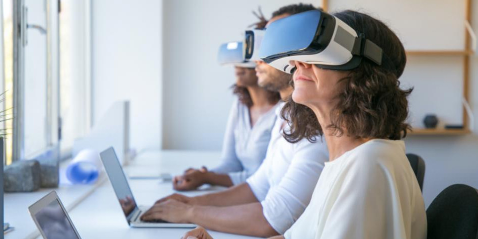 Two women and a man wearing VR headsets