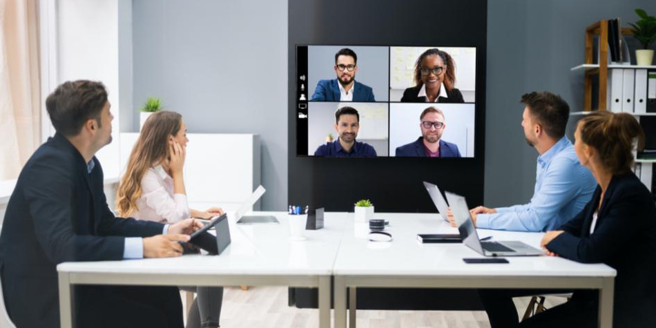 Group of people video conferencing with another