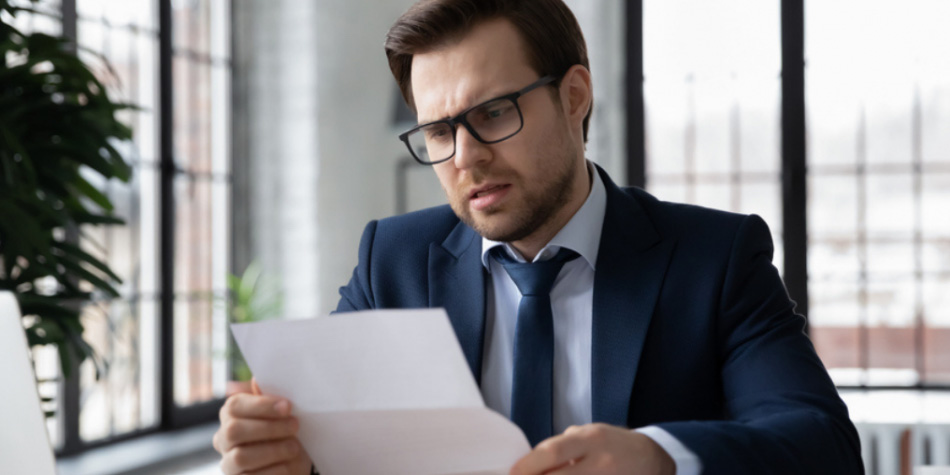 Man wearing glasses looking at contract