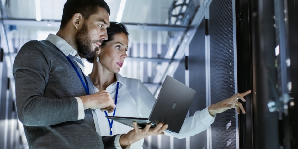 Woman and man with laptop in a server room