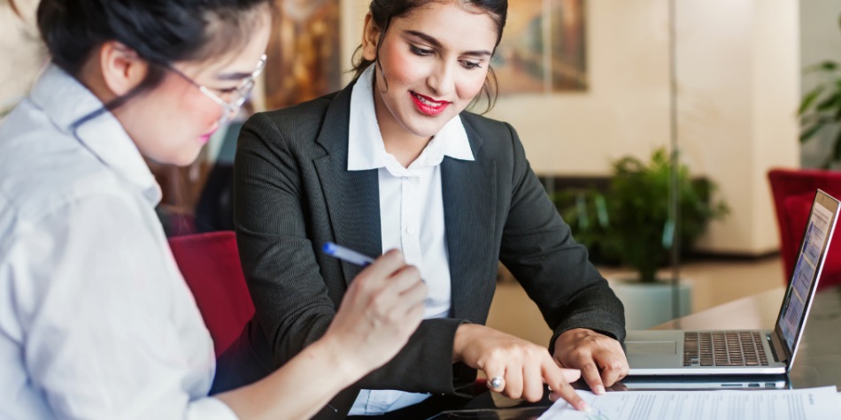 Two women signing a contract 