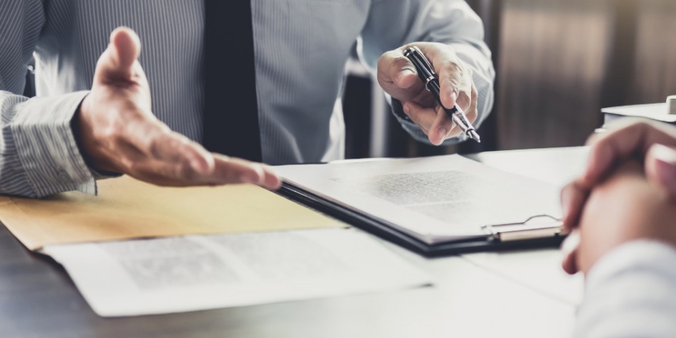 Person with tie at table with legal documents