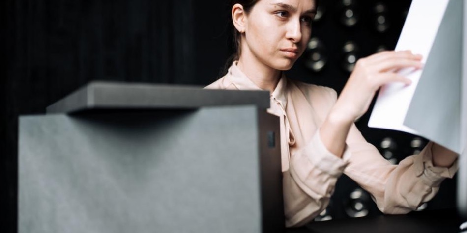 Person looking at papers near a file container