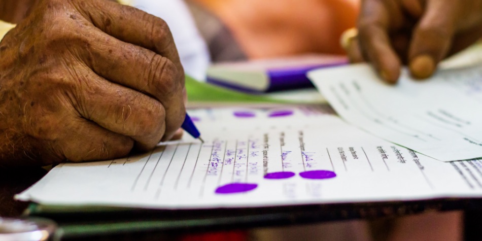 Person filling out forms with a pen